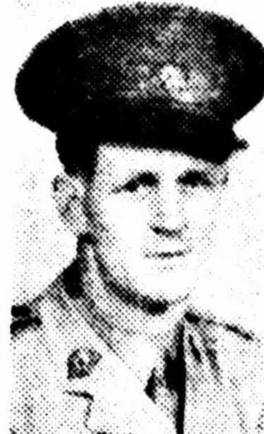 A newspaper portrait of a man in a war correspondent’s uniform and peaked cap, looking at the camera with a slight smile.